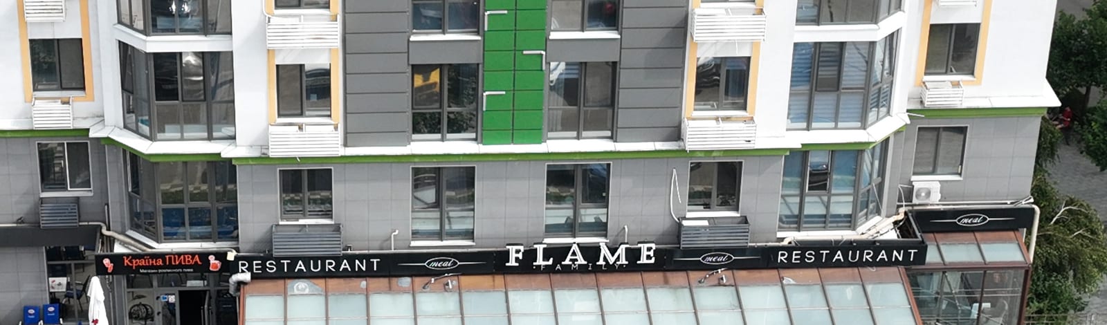 Restorano FLAME iškaba per visą SAVO namo pirmąjį aukštą, virš jo terasos