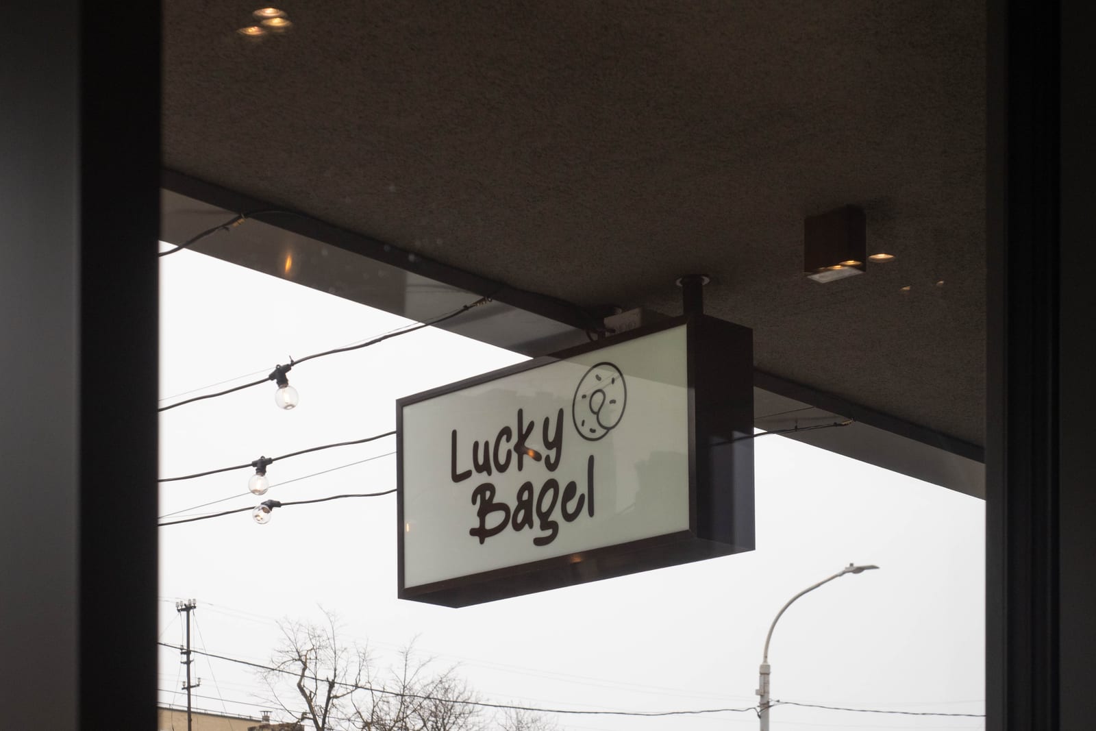 Pakabinama Lucky Bagel kavinės iškaba Vilniuje — kavinę valdo pati grupė