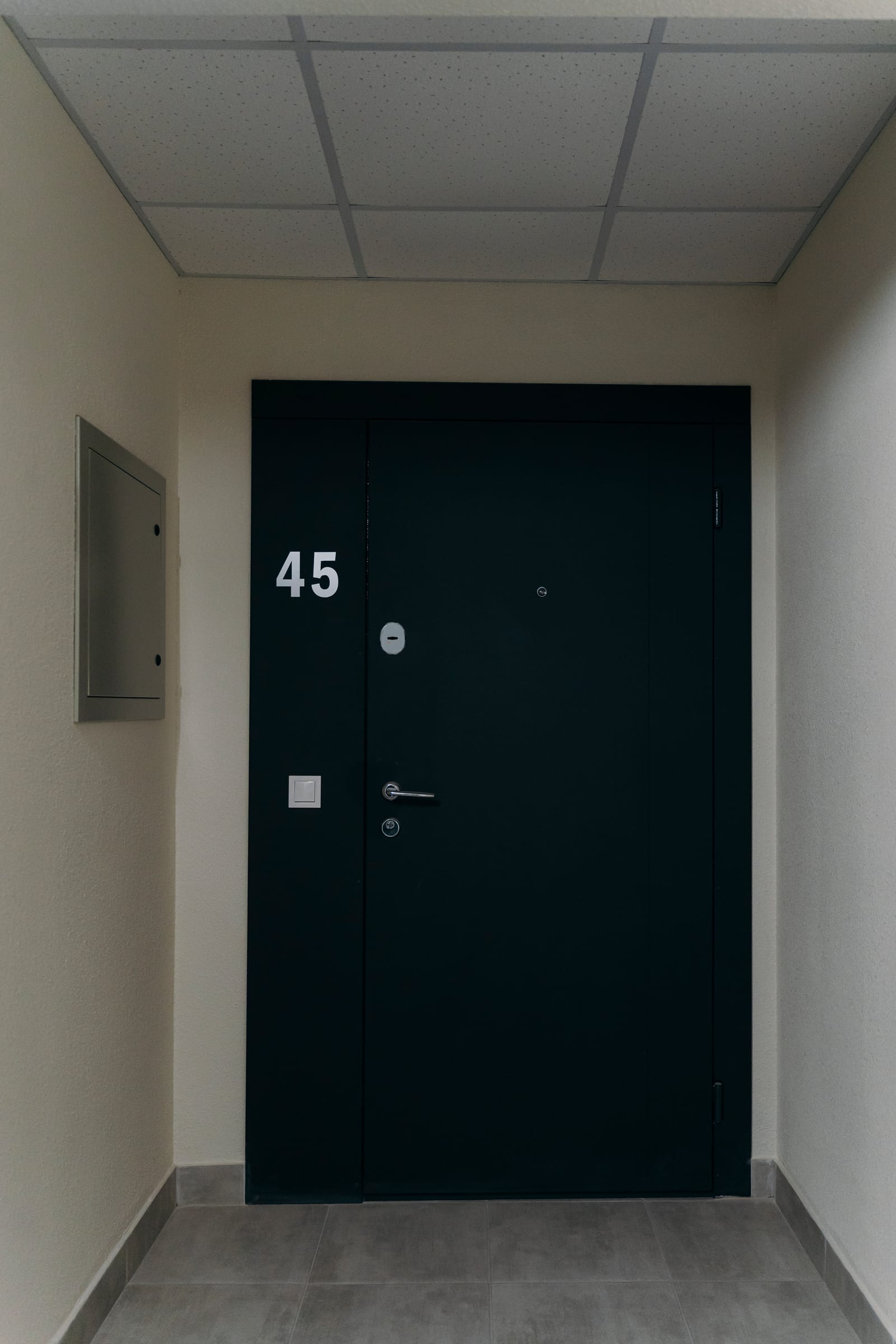 La puerta de entrada de la vivienda 45 en un edificio terminado de SAVO, vista desde el rellano común
