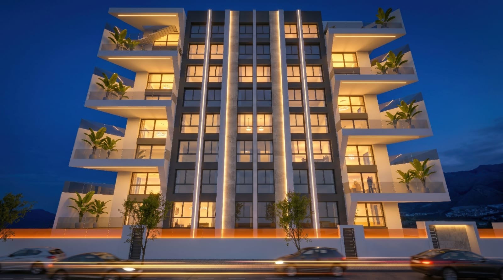Villajoyosa Residence, projectvisualisatie: het geplande gebouw bij nacht, met verlichte ramen en groene balkons