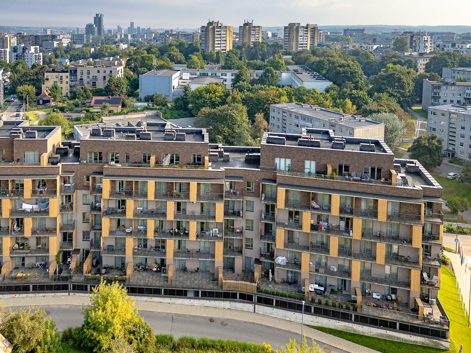 Lucky Homes by SAVO vanuit de lucht, met de woonwijken van Vilnius en de torens van het zakendistrict aan de horizon